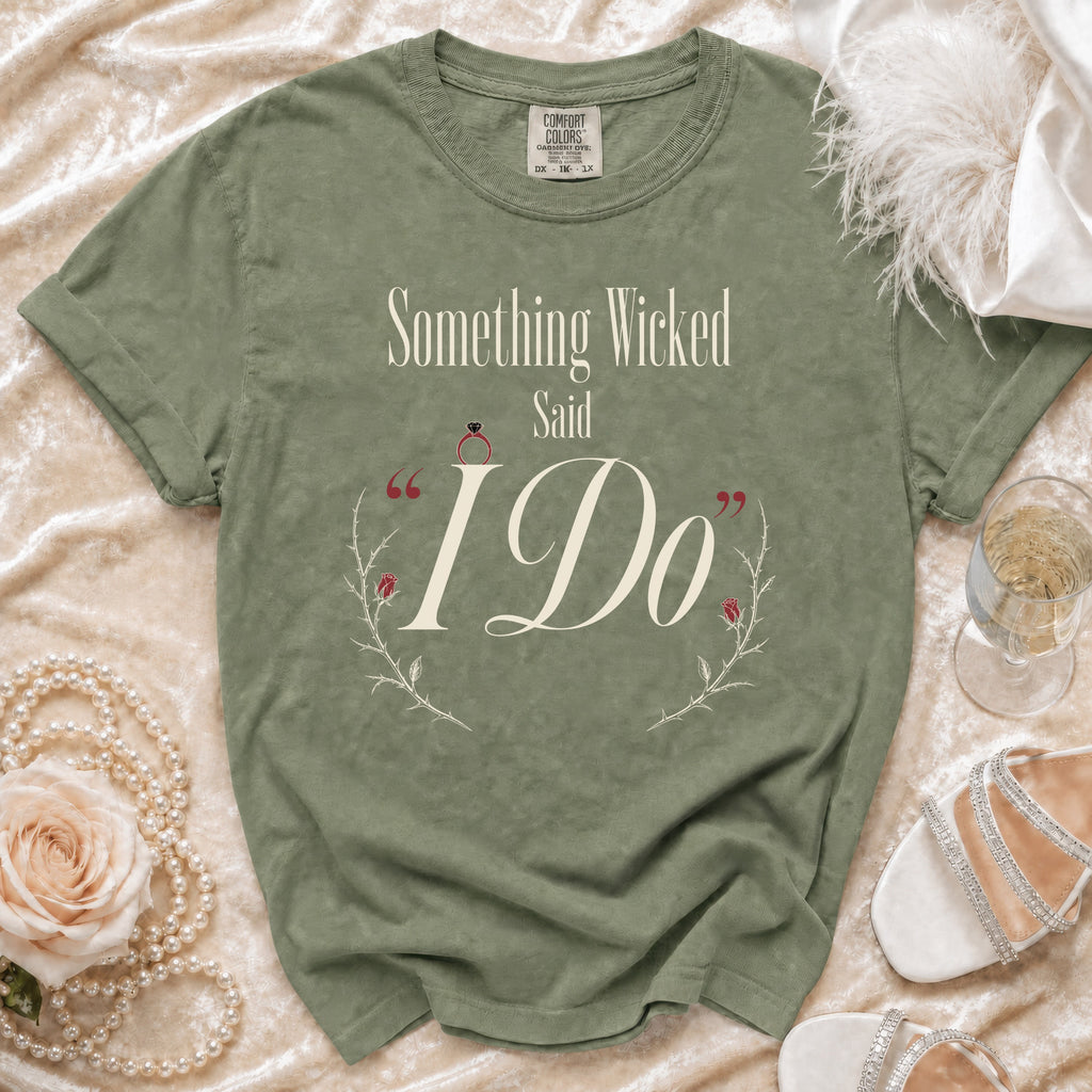 Sage green t-shirt with "Something Wicked Said I Do" text and floral accents.