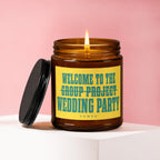Amber candle with lit wick and black lid, reads "Welcome to the wedding party."