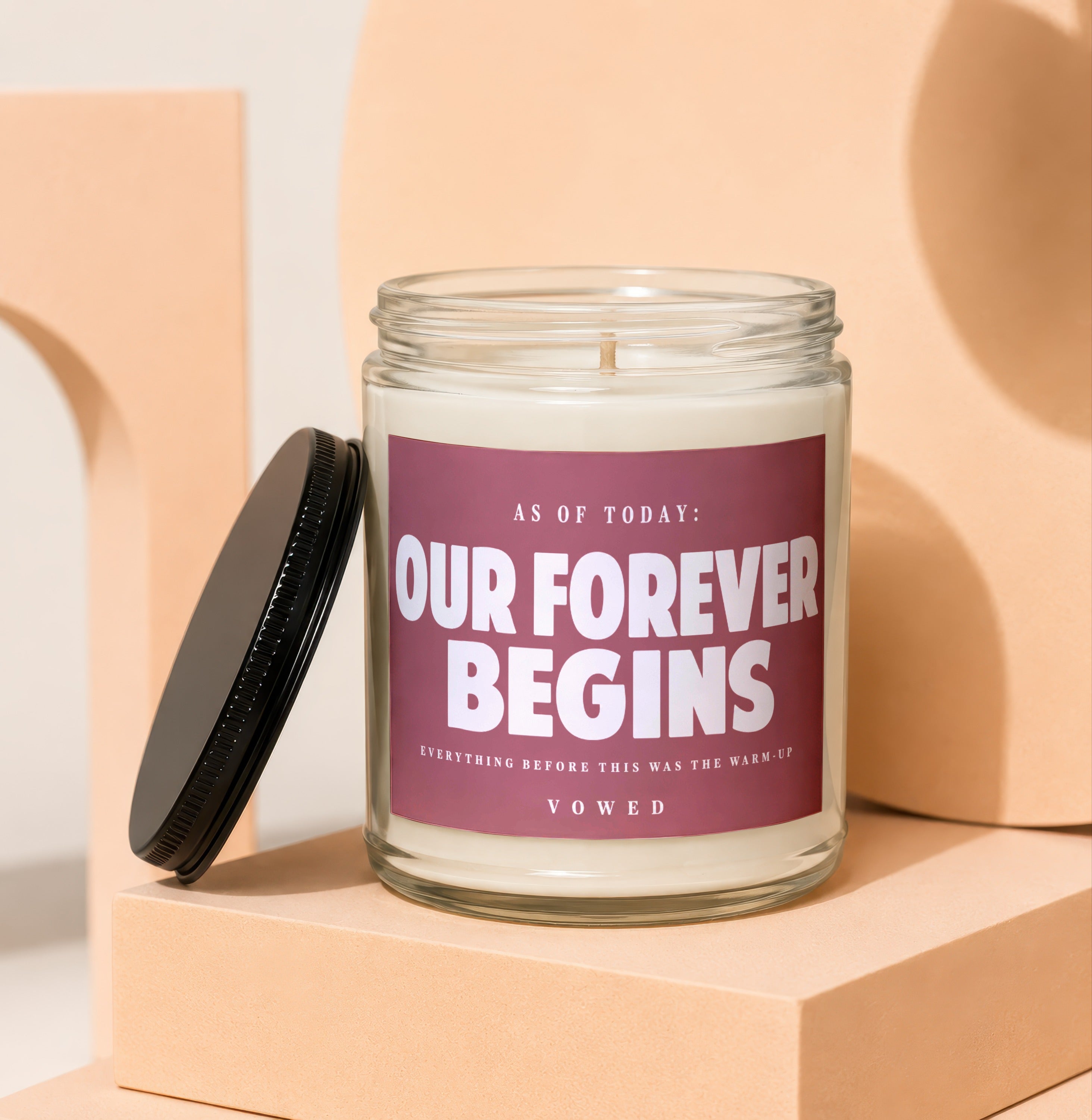 Candle with label reading "AS OF TODAY: OUR FOREVER BEGINS VOWED".
