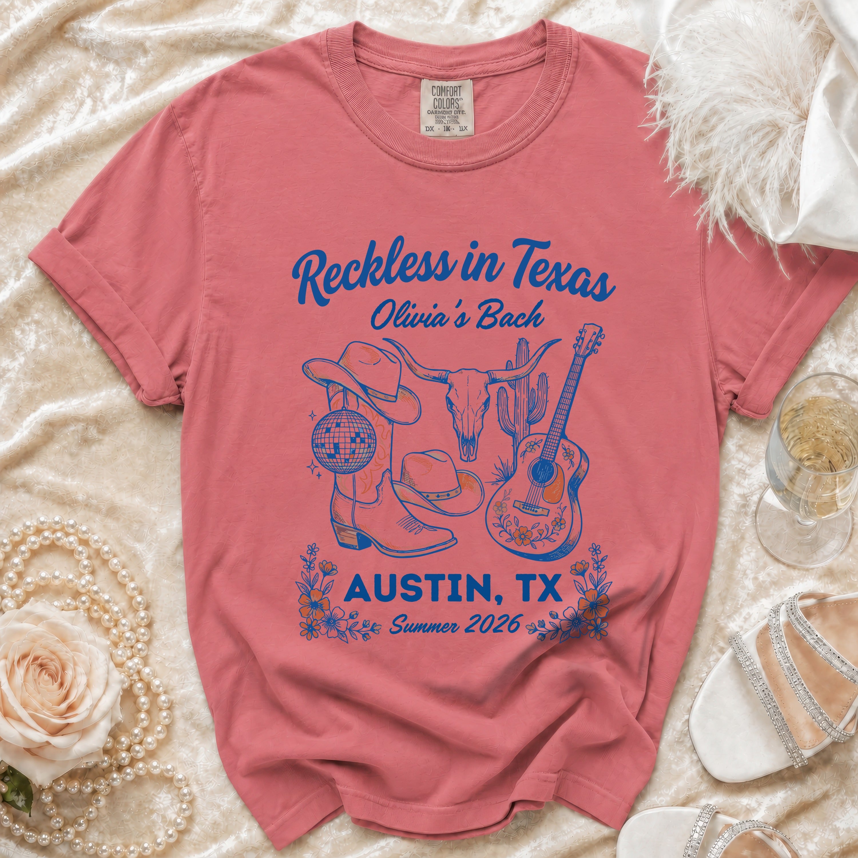 Coral t-shirt with "Reckless in Texas Olivia's Bach Austin, TX Summer 2026" text.