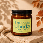 Amber candle with "Here come the brides" and "vowed" on a light green label.