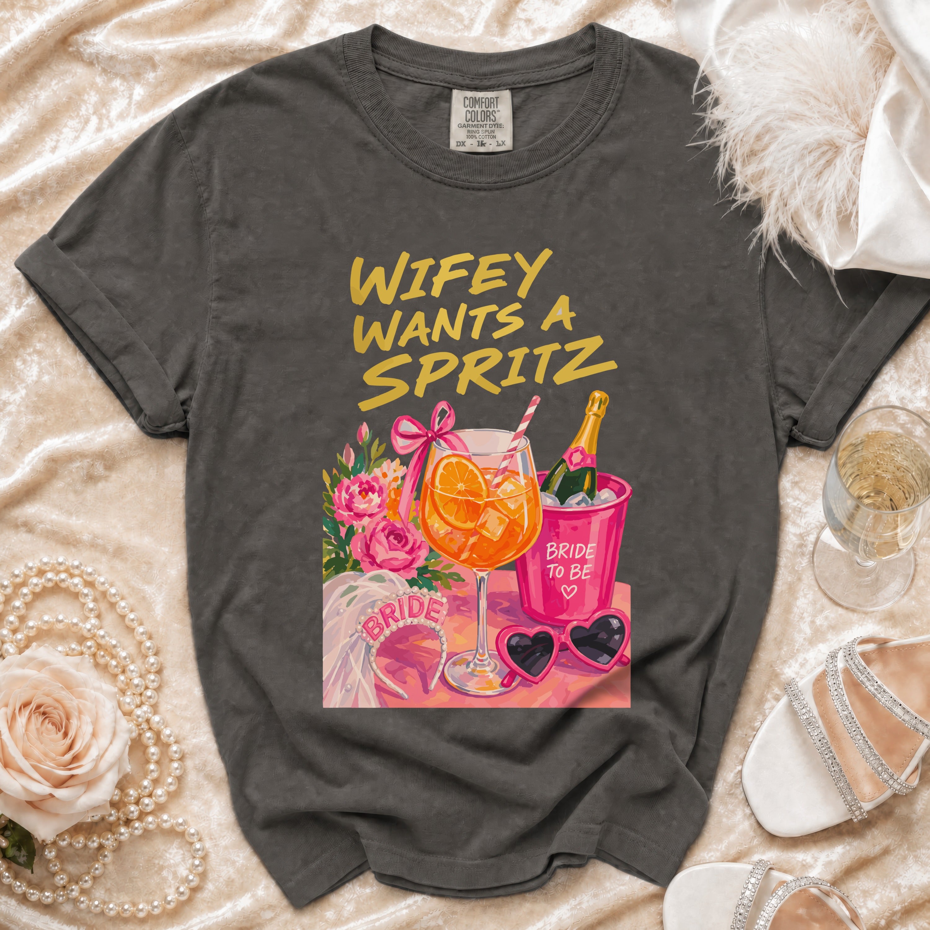 Gray t-shirt with "Wifey Wants a Spritz" design, champagne, and bridal accessories.