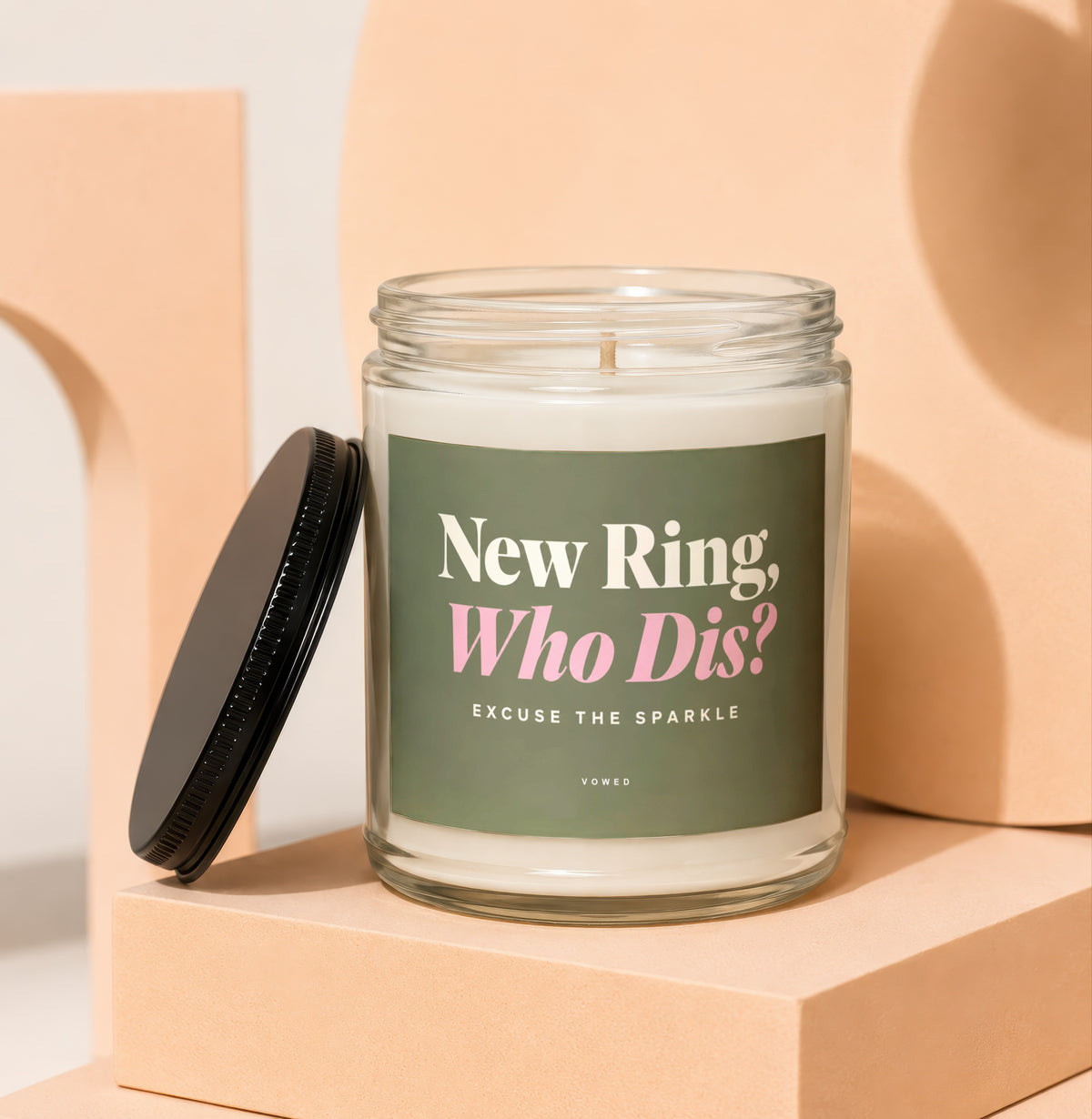 Glass candle with black lid, label reads "New Ring, Who Dis? EXCUSE THE SPARKLE VOWED".