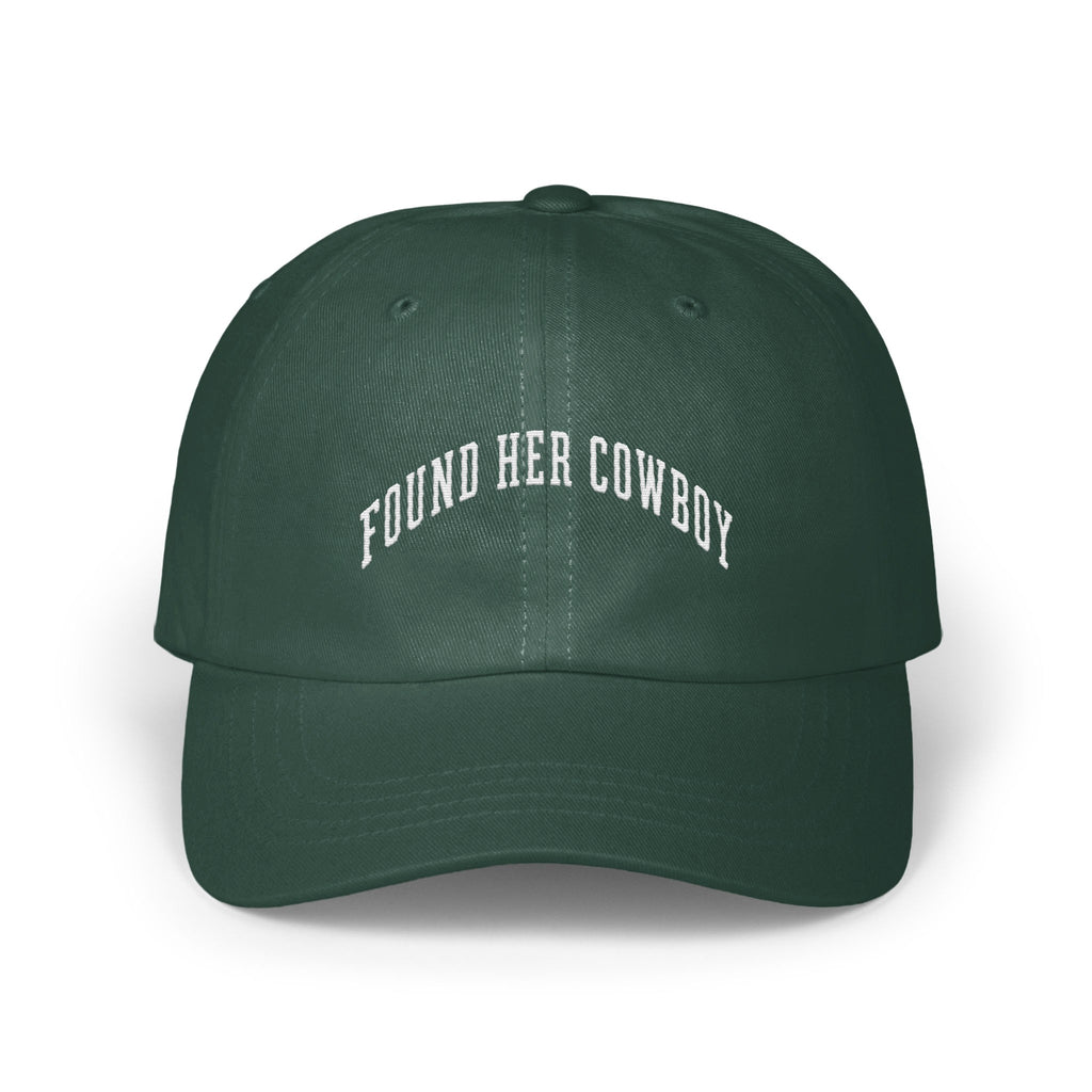 Dark green baseball cap with white embroidered text reading FOUND HER COWBOY arched across the front panels.