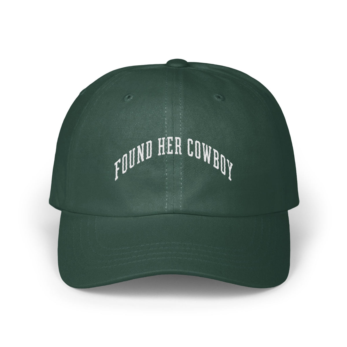 Dark green baseball cap with white embroidered text reading FOUND HER COWBOY arched across the front panels.