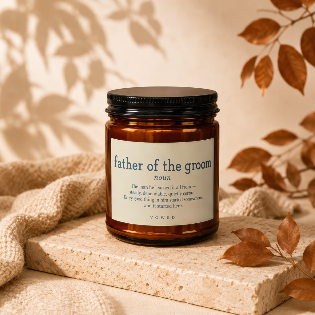 Amber candle with "father of the groom" text, against neutral background with leaves.