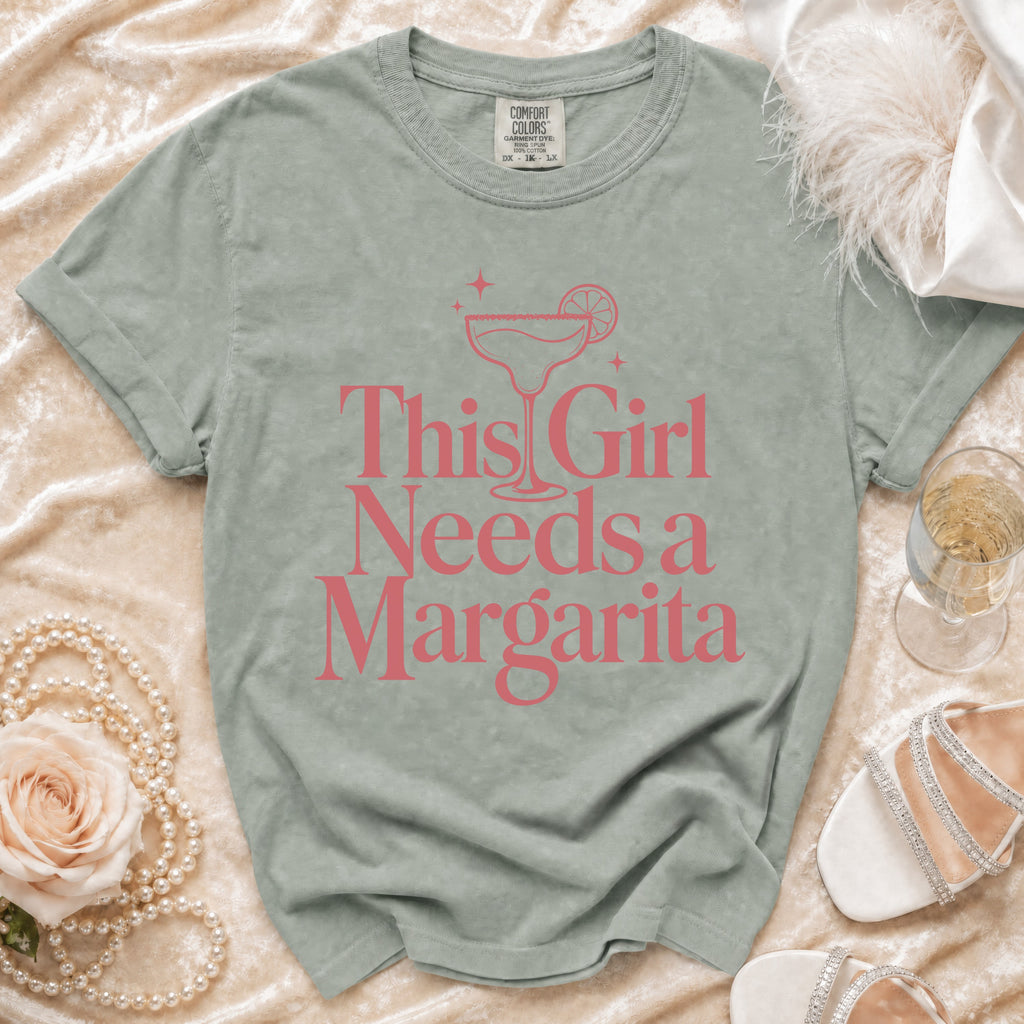 Gray t-shirt with pink text reading "This Girl Needs a Margarita" and a margarita graphic.