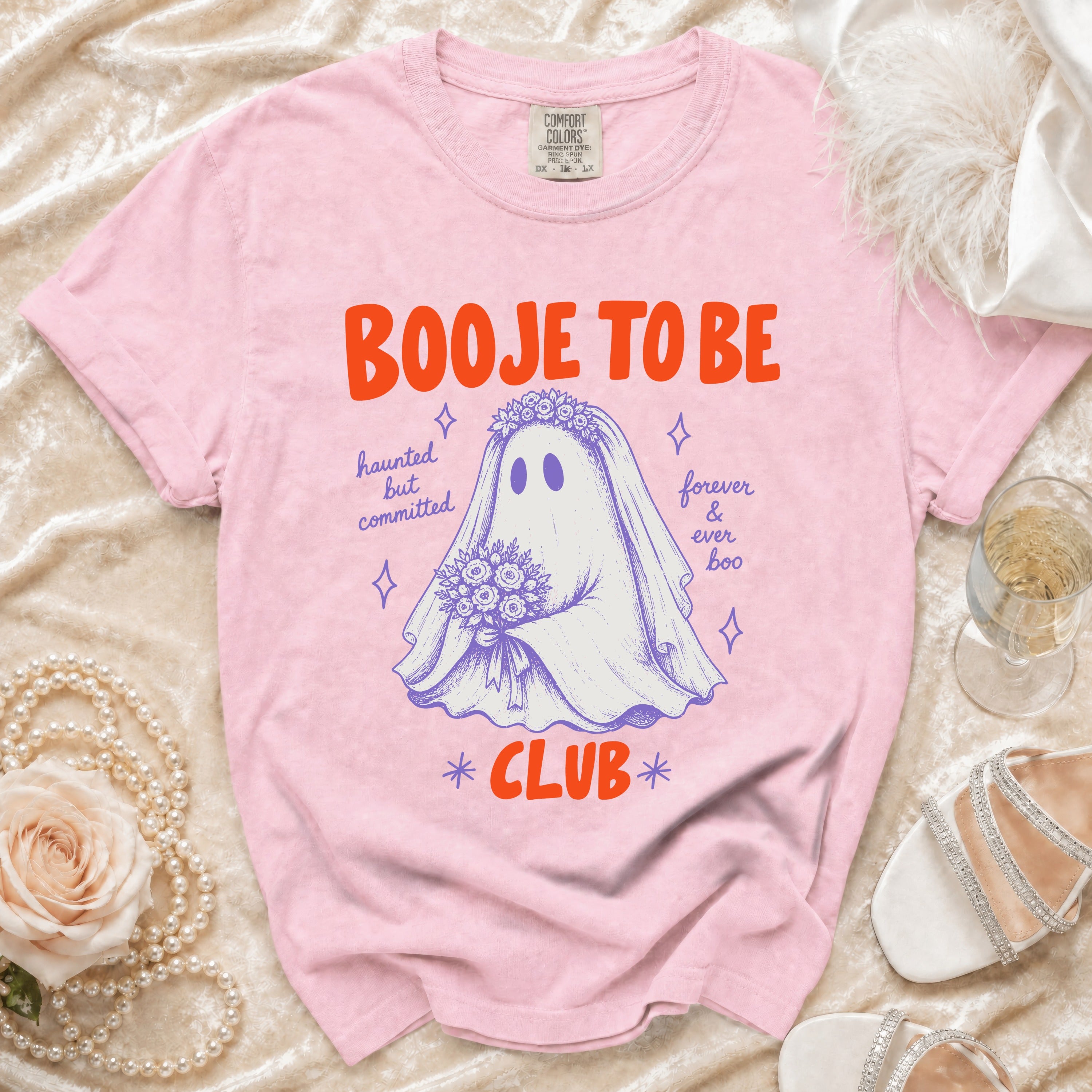 Pink t-shirt with "Booye to be haunted but committed forever & ever boo club" graphic.