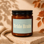 Amber jar candle with "Bride Brain" and "Vowed" text on a light blue label.