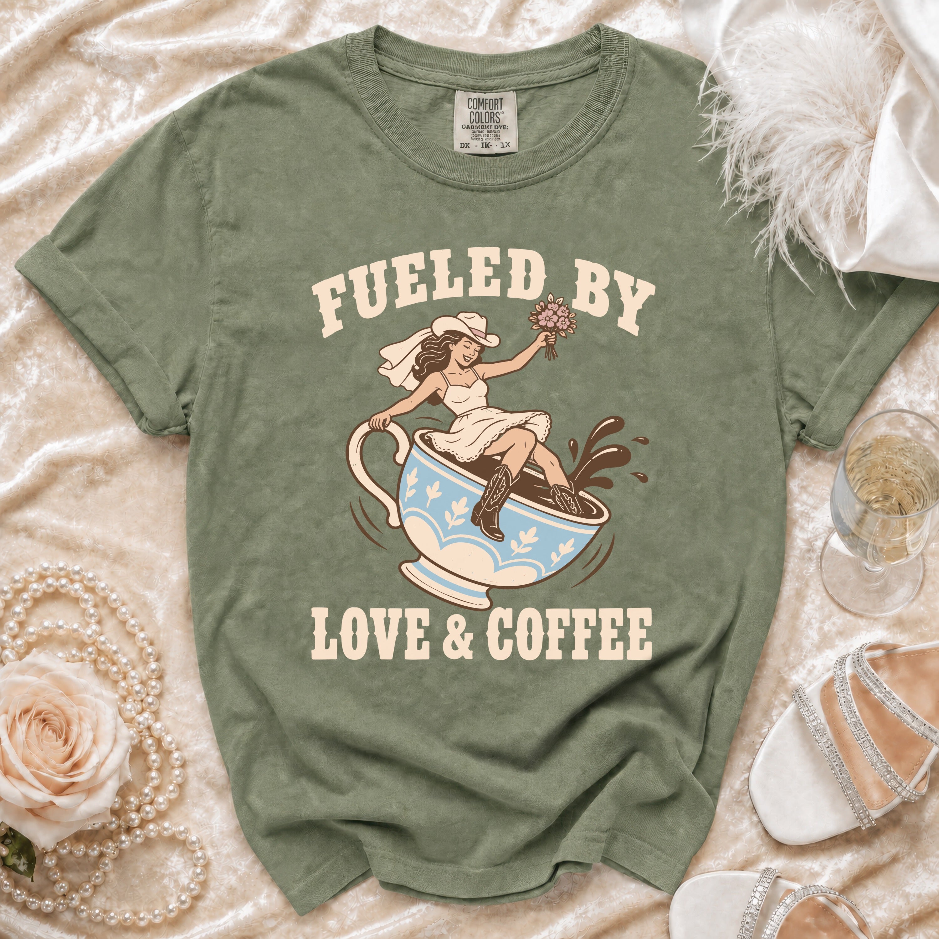 Green t-shirt with bride riding coffee cup graphic and text "Fueled by Love & Coffee".