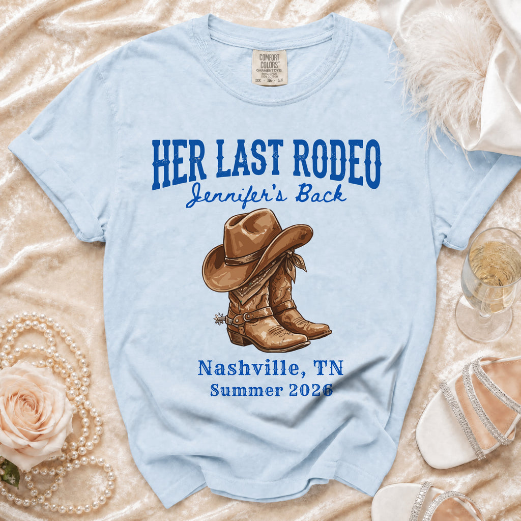 Light blue t-shirt with "Her Last Rodeo" text and cowboy boots graphic.