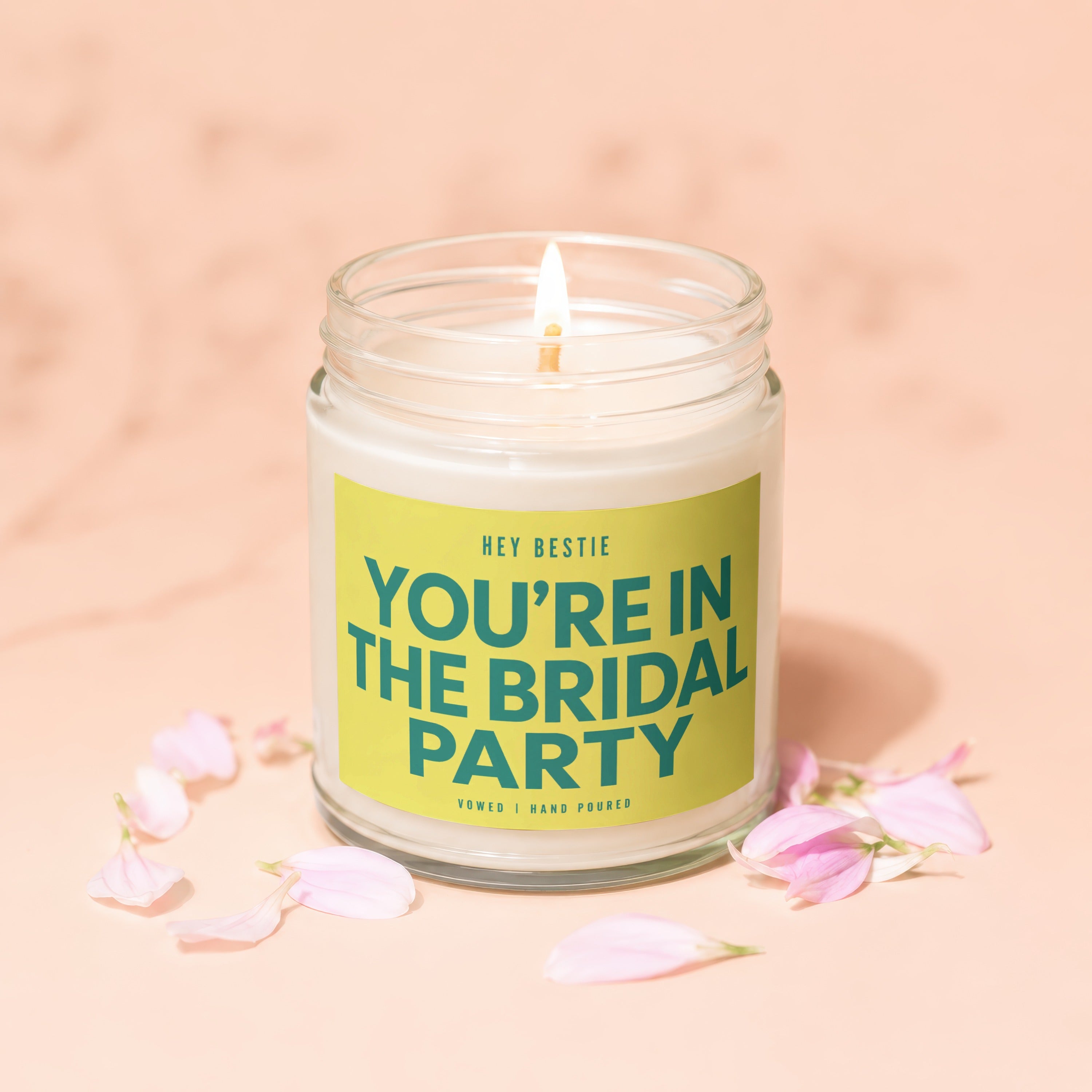 Glass jar candle with lit wick, featuring "YOU'RE IN THE BRIDAL PARTY" text.