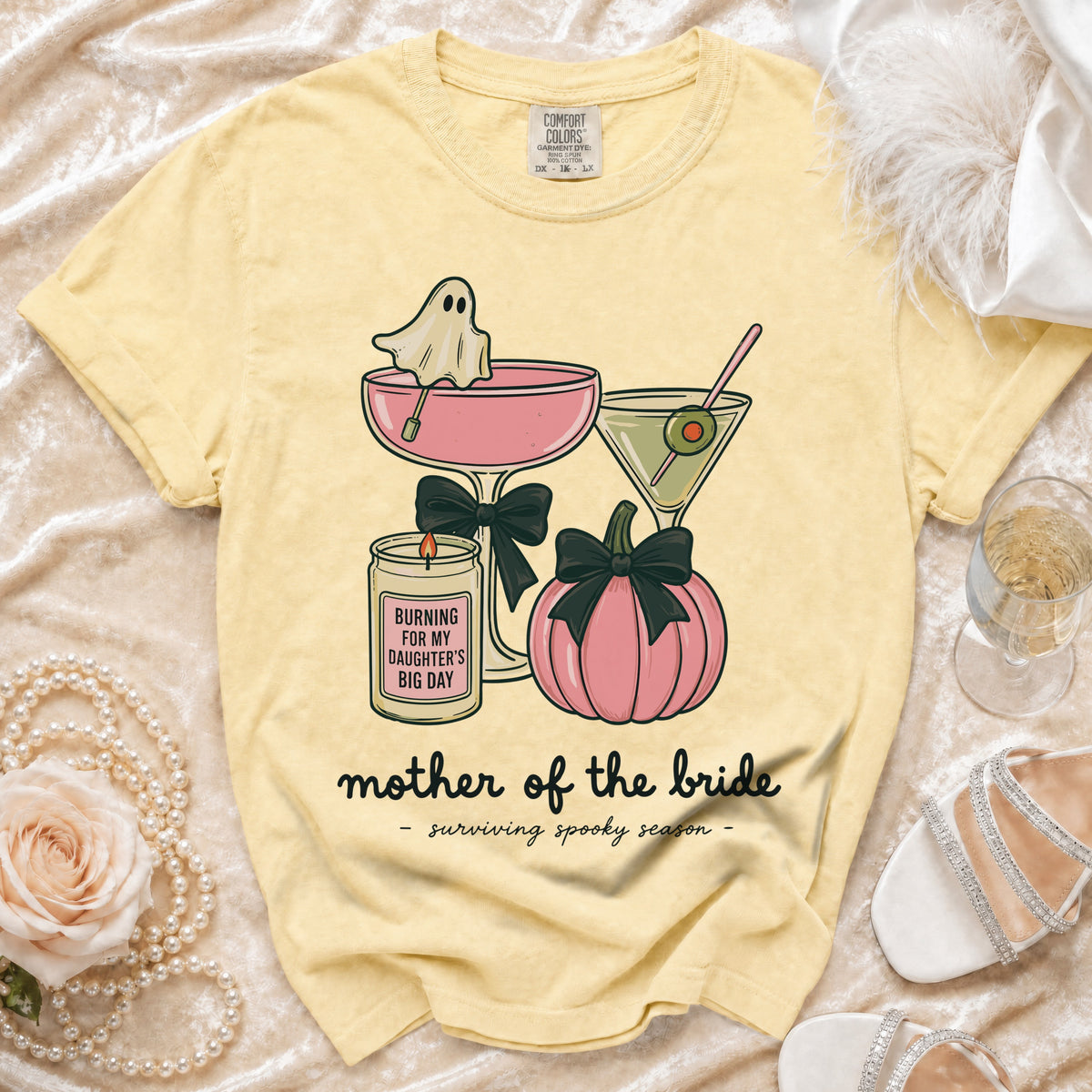 Yellow t-shirt with ghost, candle, pumpkin, and text "mother of the bride - surviving spooky season".