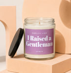 Glass candle with purple label reading "Smells Like I Raised a Gentleman Vowed".