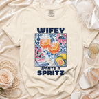 Cream t-shirt with "Wifey Wants A Spritz" graphic of drinks and fruit.