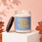 Candle with "Here for the 1920s" text on blue label, lid open.