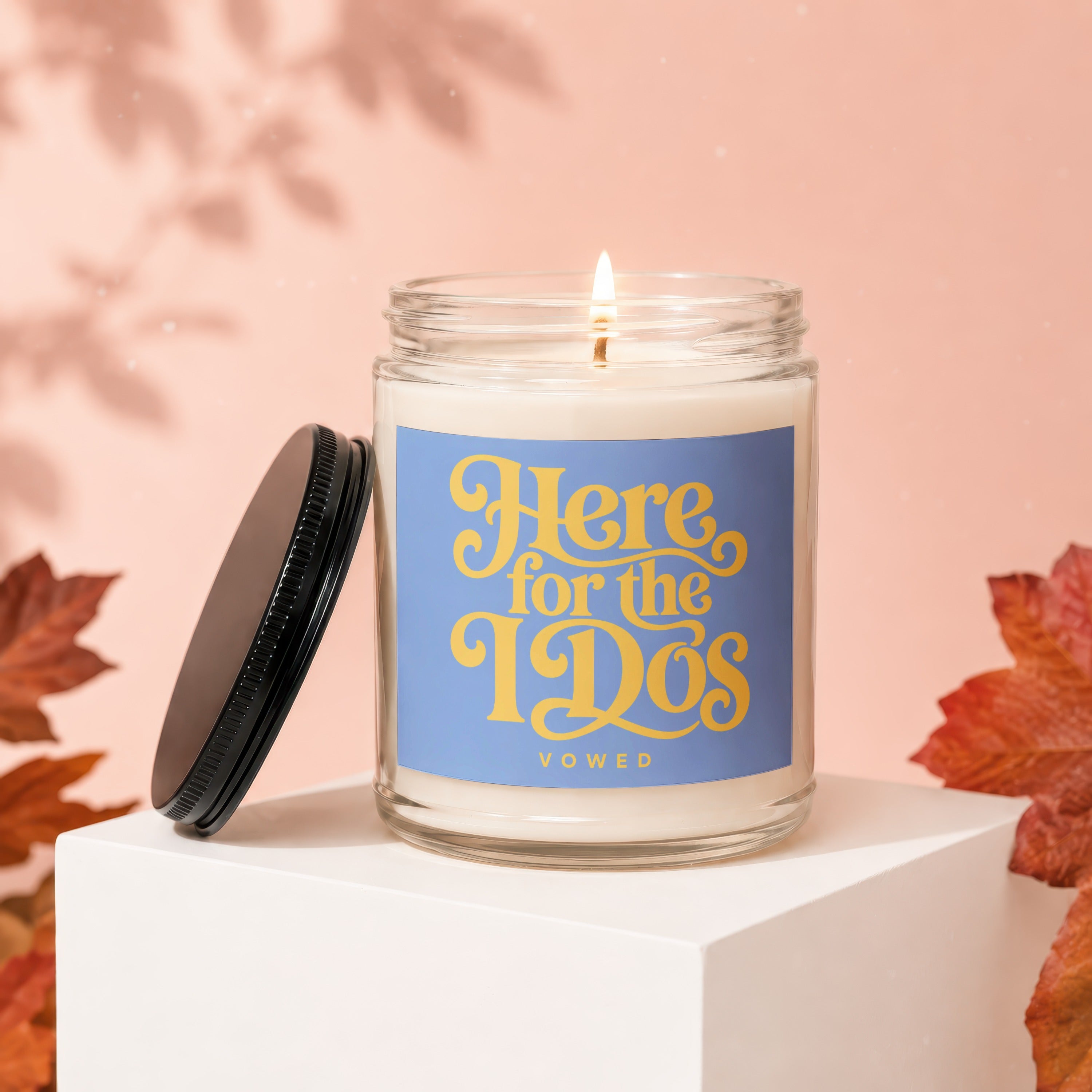 Candle with "Here for the 1920s" text on blue label, lid open.