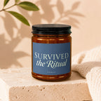Brown glass candle with a blue label that reads "SURVIVED the Ritual" and "VOWED."