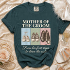 Teal t-shirt with "Mother of the Groom" text and three shoe illustrations: baby booties, sneakers, dress shoes.