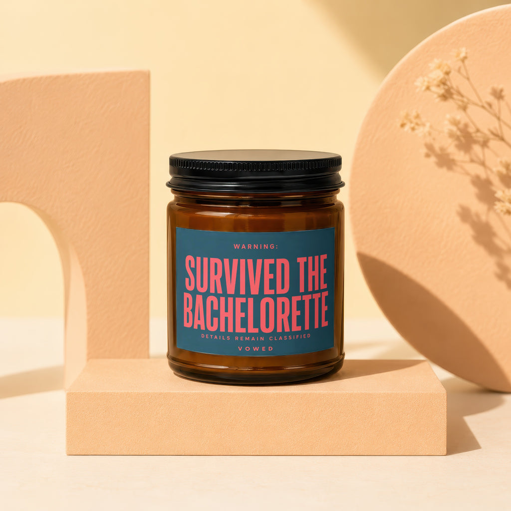 Amber jar candle with "SURVIVED THE BACHELORETTE" in pink lettering on the label.