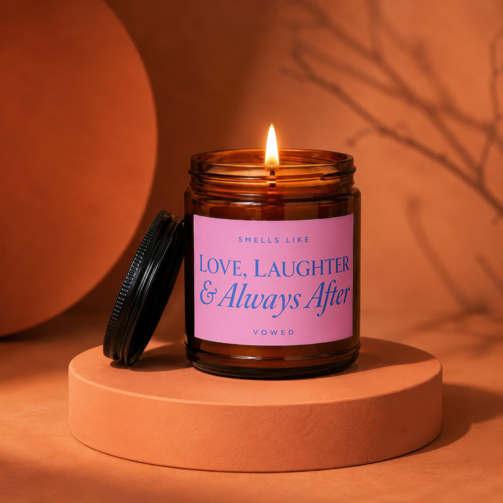 Burning amber candle with pink label text "Love, Laughter & Always After"