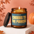 Amber glass candle with "Cheers to the Fiancés" text and pumpkin accent.