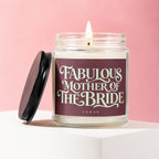 Glass candle with lit wick, burgundy label reading "Fabulous Mother of The Bride".