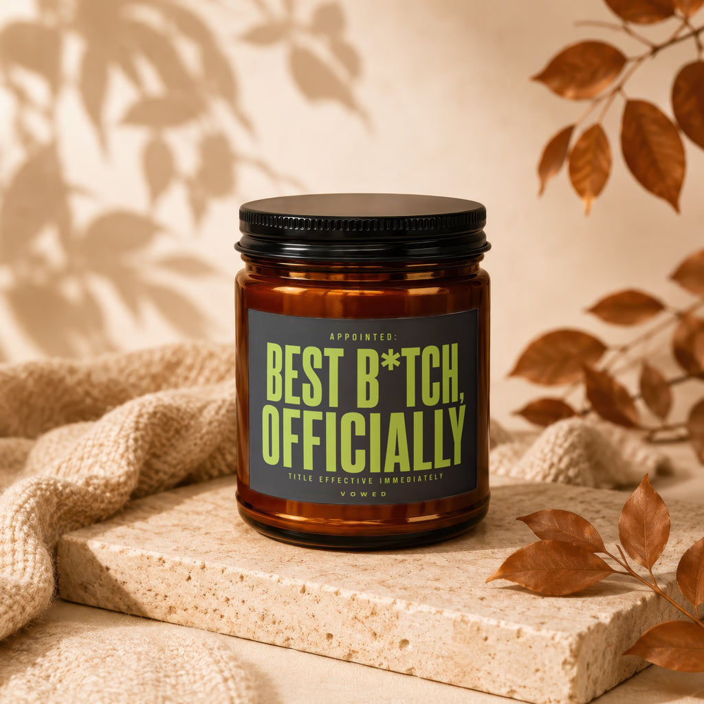 Amber jar candle with black lid labeled "Best B*tch, Officially" in neon green.