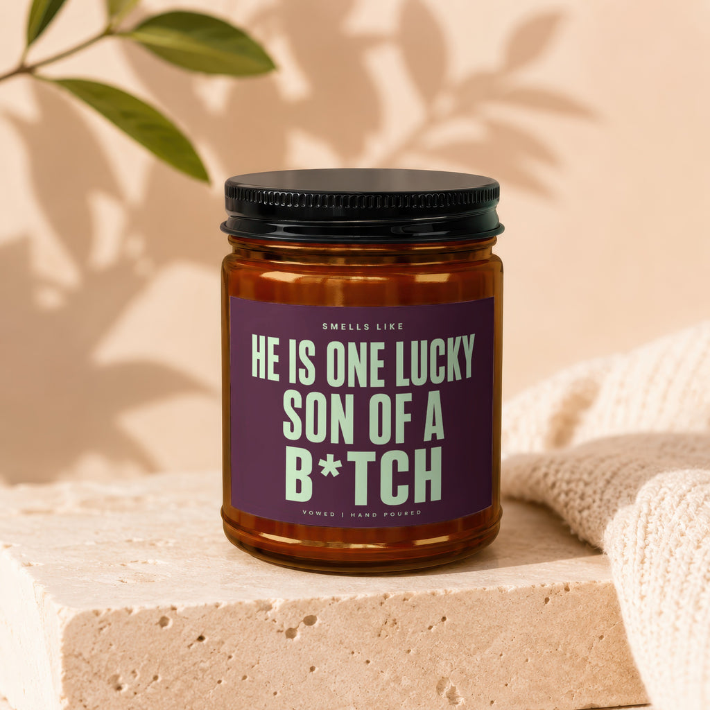 Candle with text "HE IS ONE LUCKY SON OF A B*TCH", hand-poured.