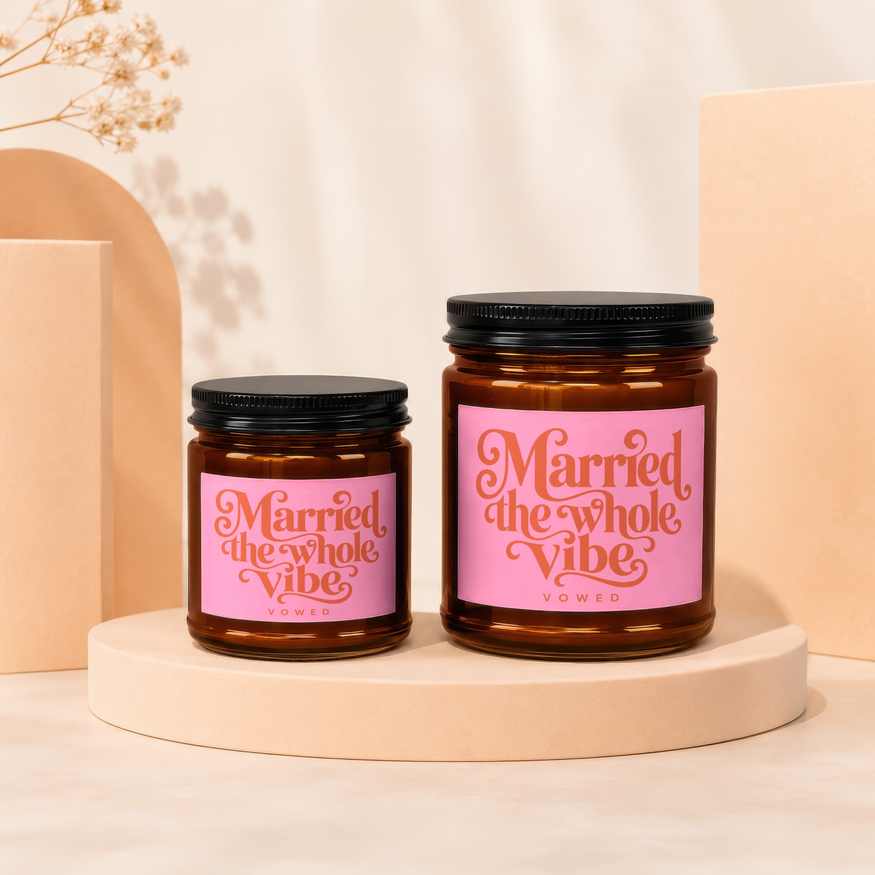 Two brown glass candles with pink labels that say "Married the whole Vibe."