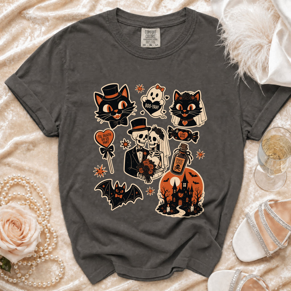Dark grey t-shirt with Halloween-themed graphic featuring cats, skeletons, bats, and a haunted house.