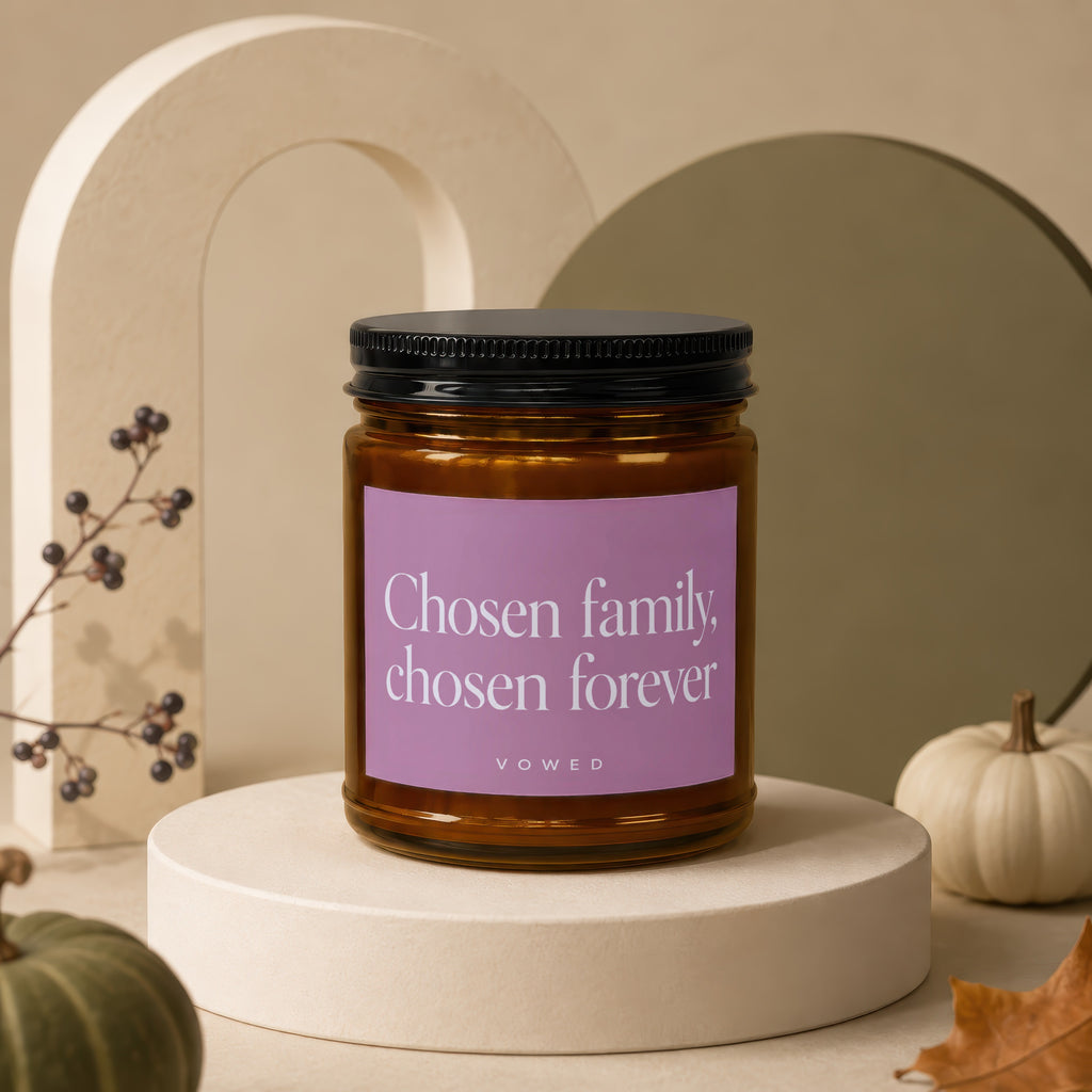 Amber candle with a purple label reading "Chosen family, chosen forever" with the word "vowed" at the bottom.