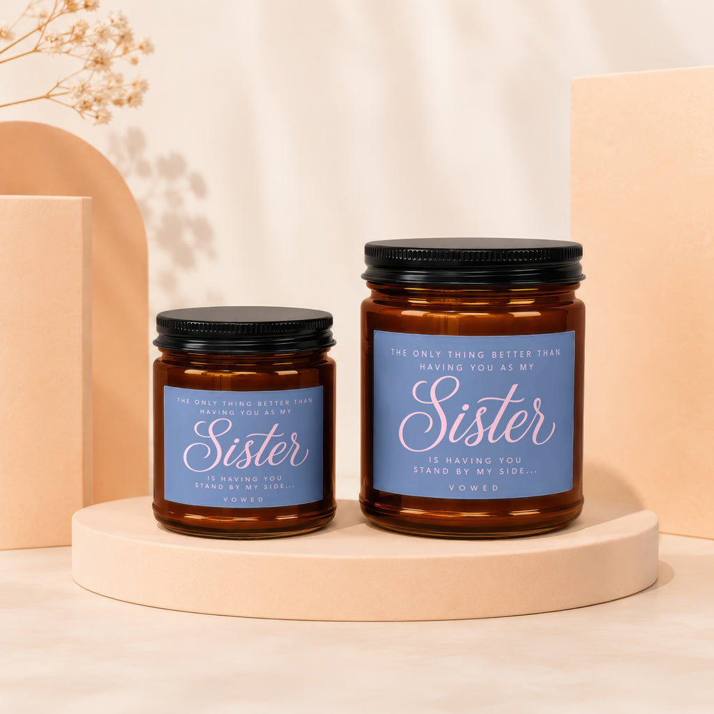 Two amber glass candles with black lids, one larger than the other, labeled "Sister".