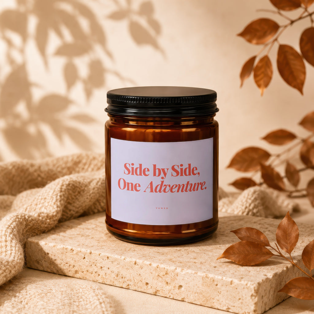 Amber glass candle with black lid, reads "Side by Side, One Adventure."