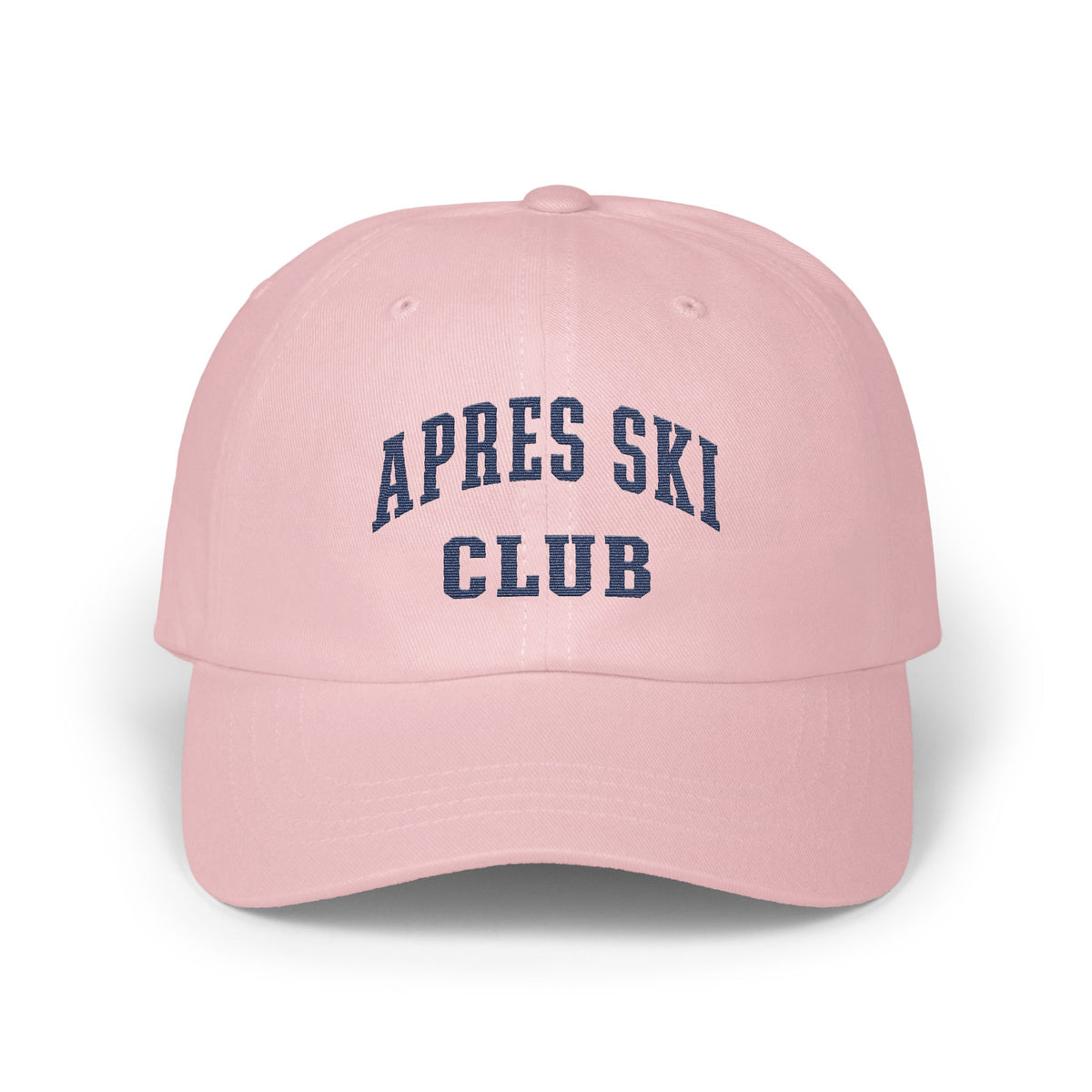 Light pink baseball cap embroidered with dark blue text reading Apres Ski Club.
