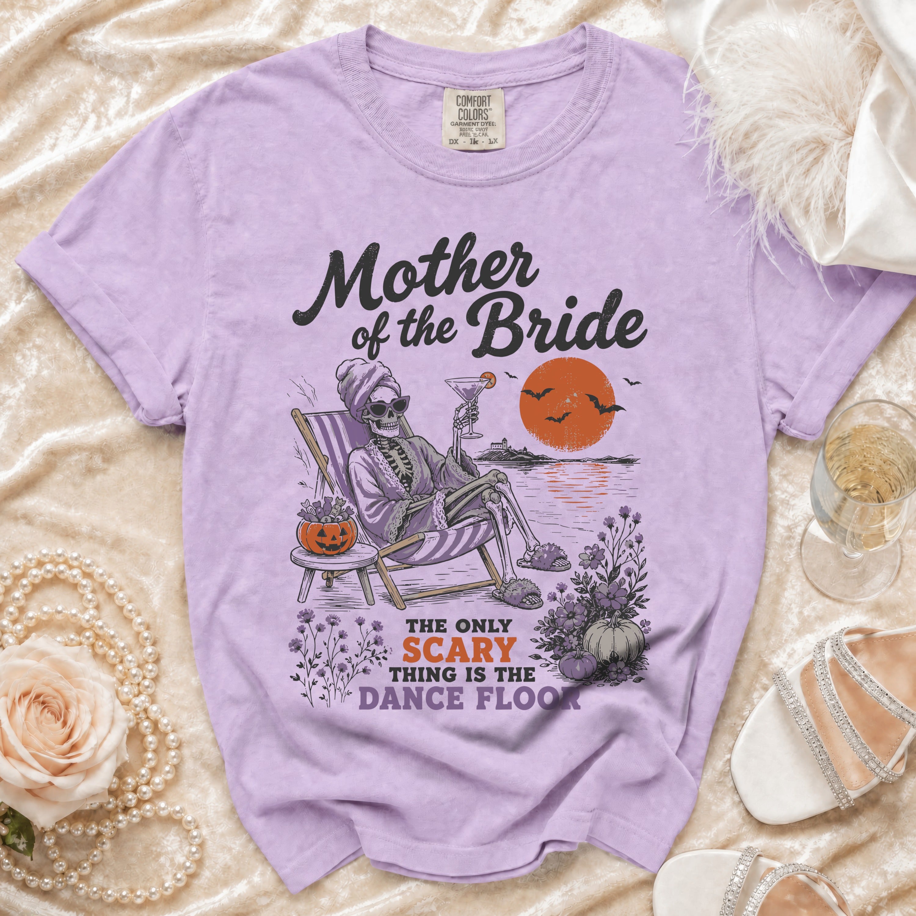 Purple t-shirt with "Mother of the Bride" graphic and skeleton on beach chair.
