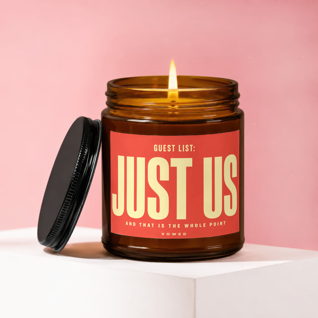 Amber jar candle with red label reading "Guest List: Just Us" and "vowed".