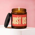 Amber jar candle with red label reading "Guest List: Just Us" and "vowed".