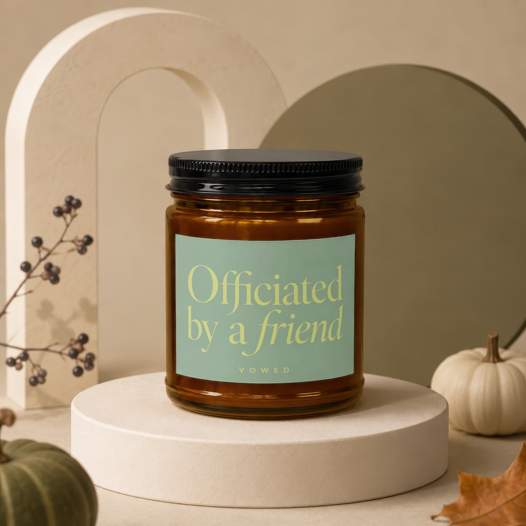 Amber candle with black lid, light green label reading "Officiated by a friend" and "VOWED".