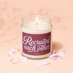 Candle with lit wick, burgundy label reading "Recruited each other VOWED".