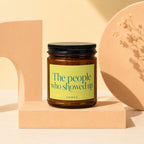 Amber candle with yellow label reading "The people who showed up VOWED".