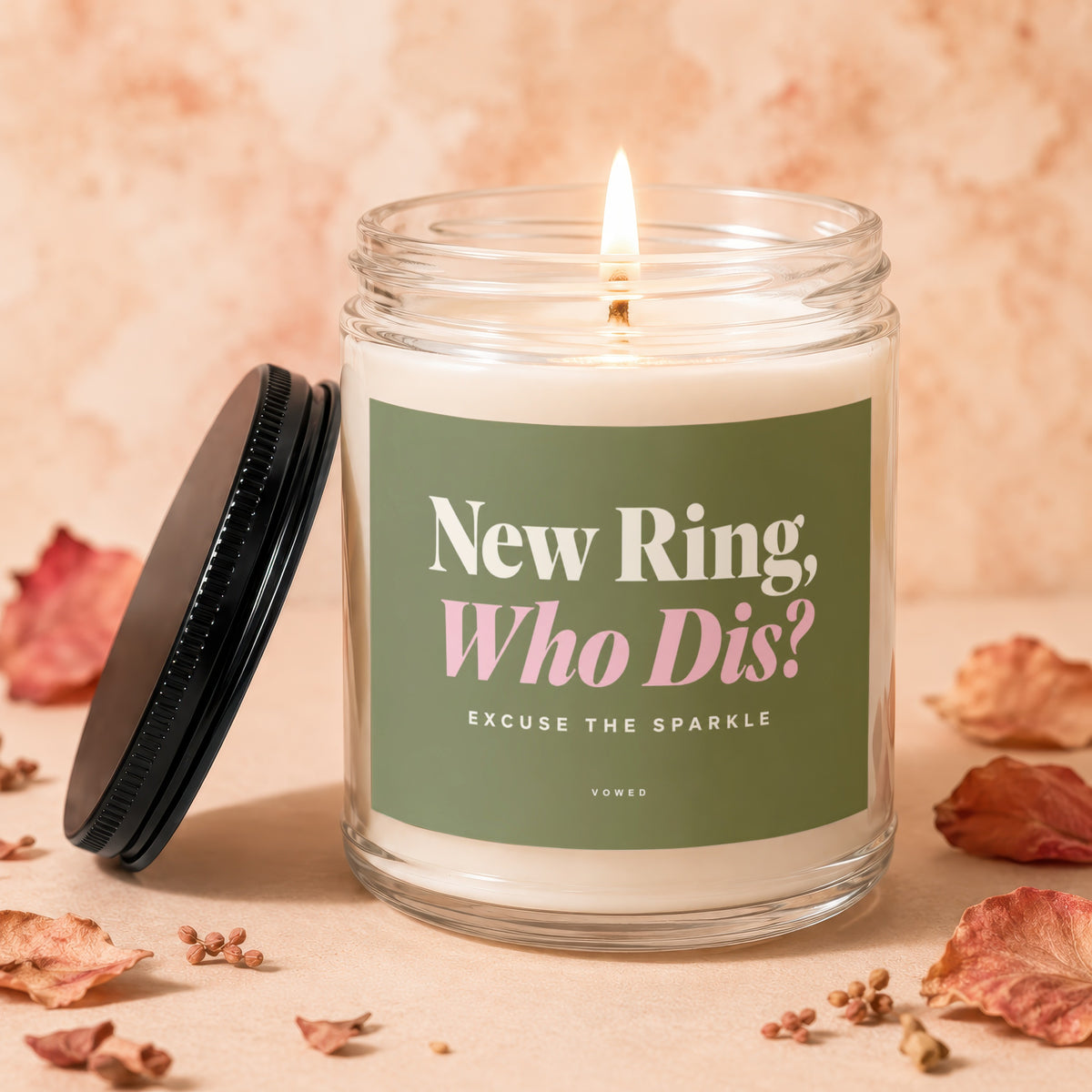 Glass candle with green label reading "New Ring, Who Dis?".
