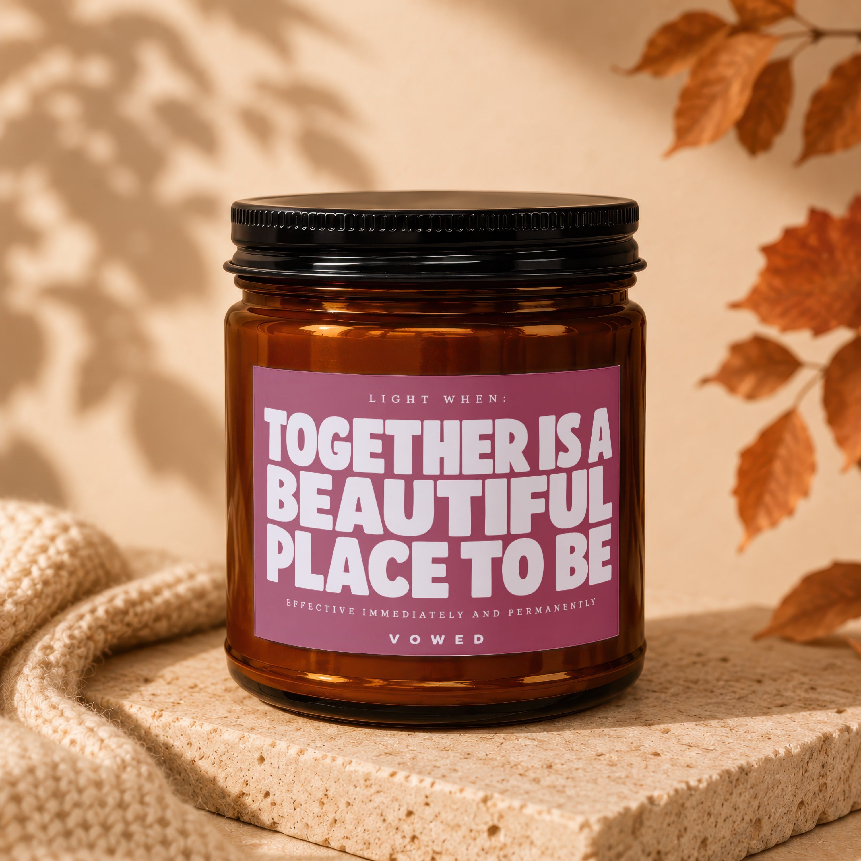 Amber jar candle with black lid, pink label reads "Together is a beautiful place to be".