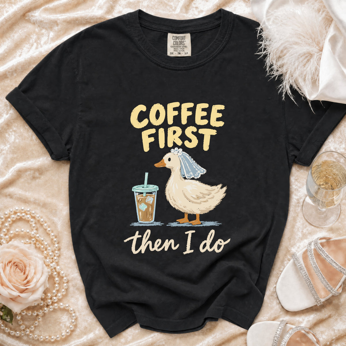Black t-shirt with a duck wearing a veil and holding coffee, saying "Coffee First then I Do".