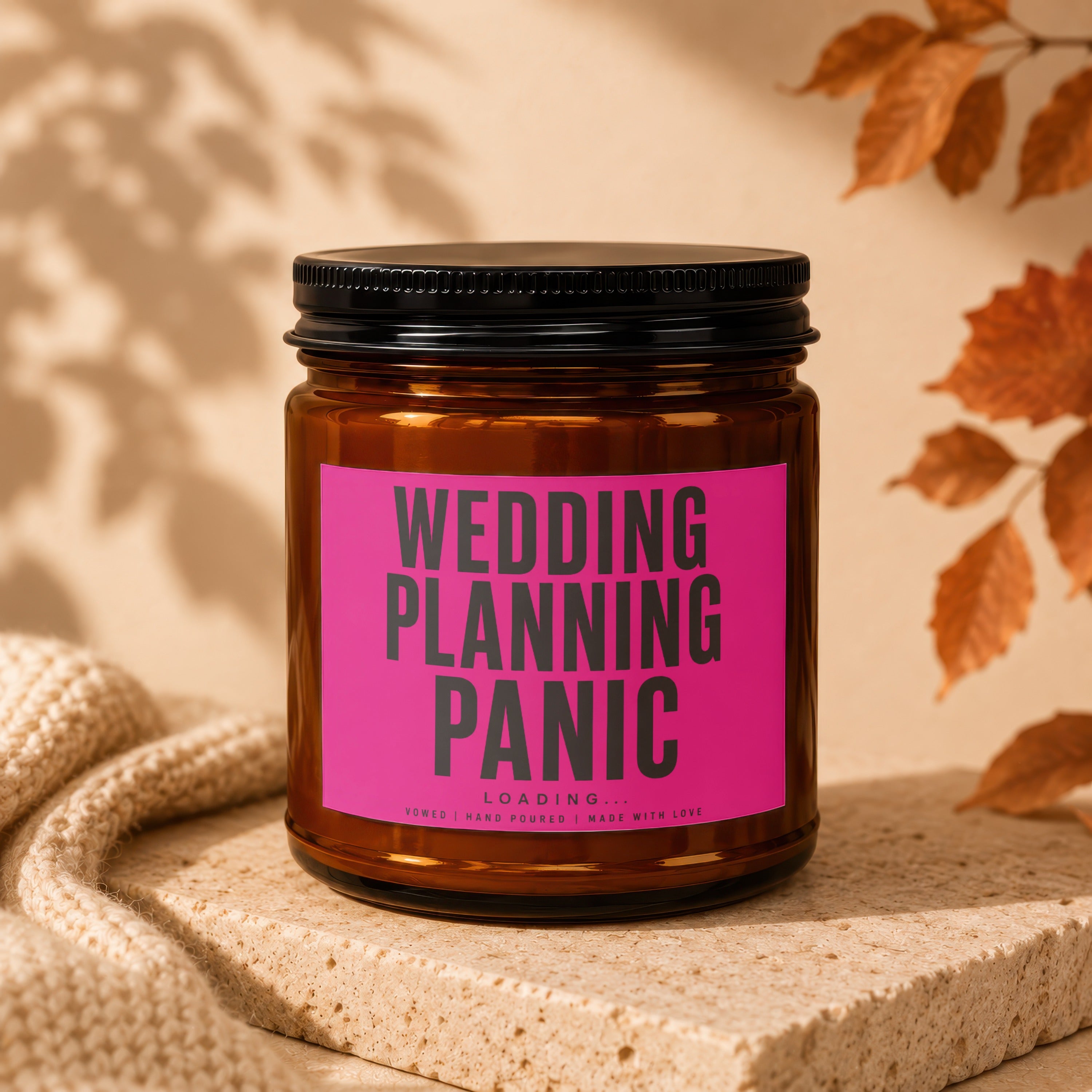 Amber candle in jar with pink label reading WEDDING PLANNING PANIC LOADING... VOWED.