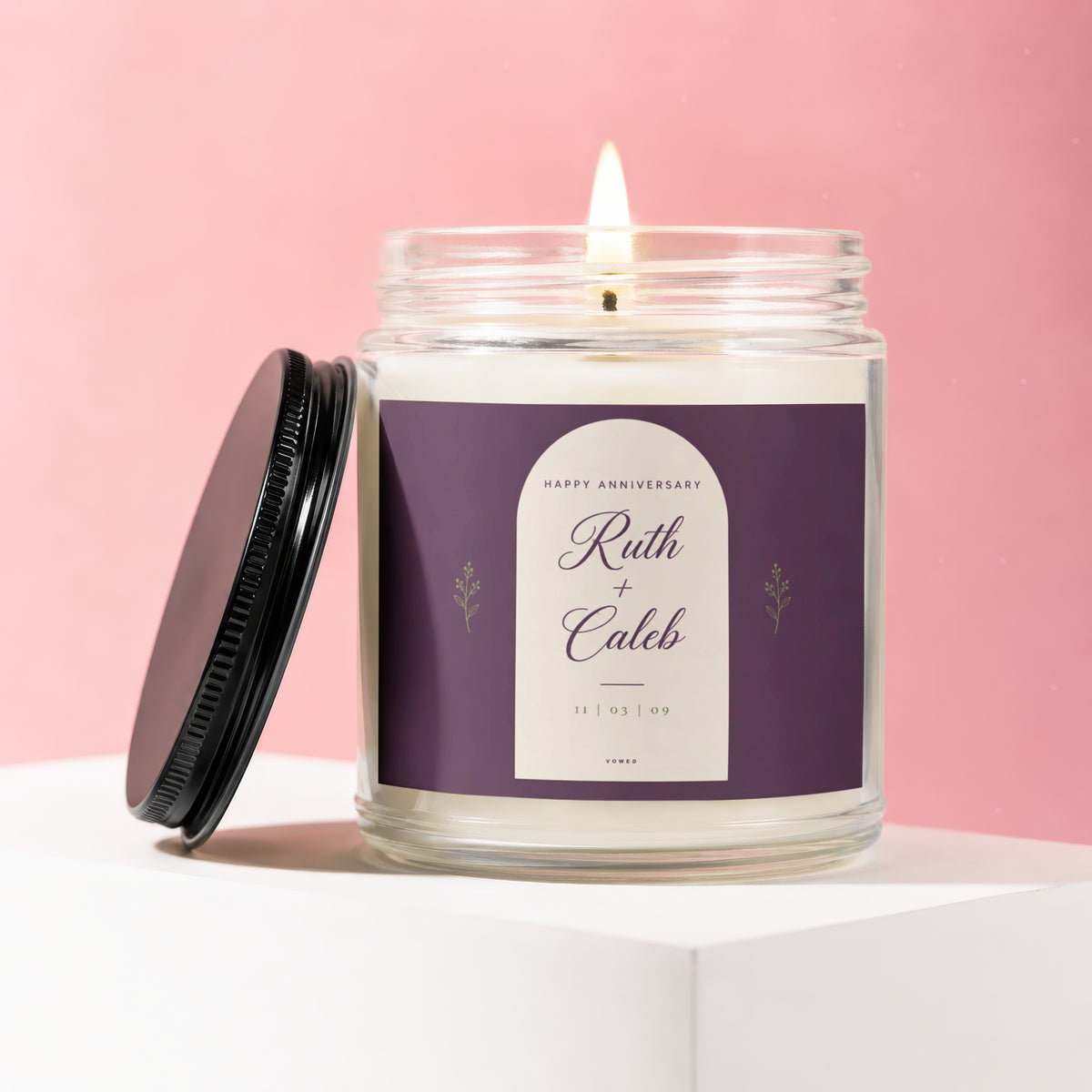 Glass anniversary candle with "Ruth + Caleb 11 | 03 | 09" on the label.