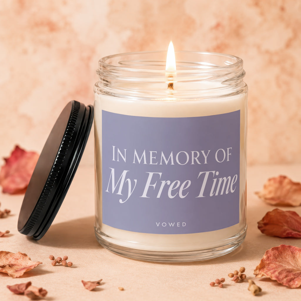 Glass candle with lit flame, "In Memory of My Free Time" text, and dried leaves.
