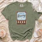 Green t-shirt with "Love is brewing" coffee cup graphic and matchstick design.