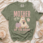 An olive green t-shirt with a vintage-style graphic of a ghost wearing floral wreaths and text reading Mother of the Bride.