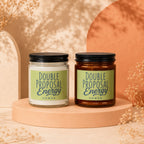 Two "Double Proposal Energy" scented candles with "VOWED" text, one clear, one amber.